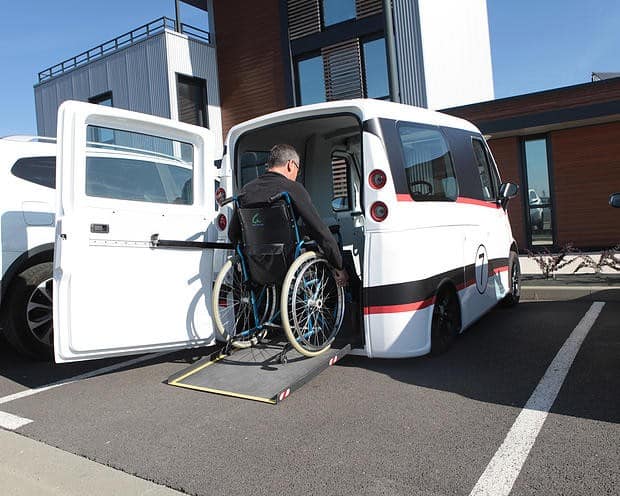 La voiture Kimsi sort une rampe pour pouvoir y entrer en fauteuil roulant